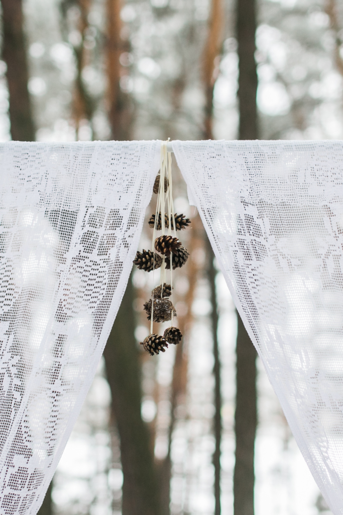 Lace winter wedding arch with pinecones