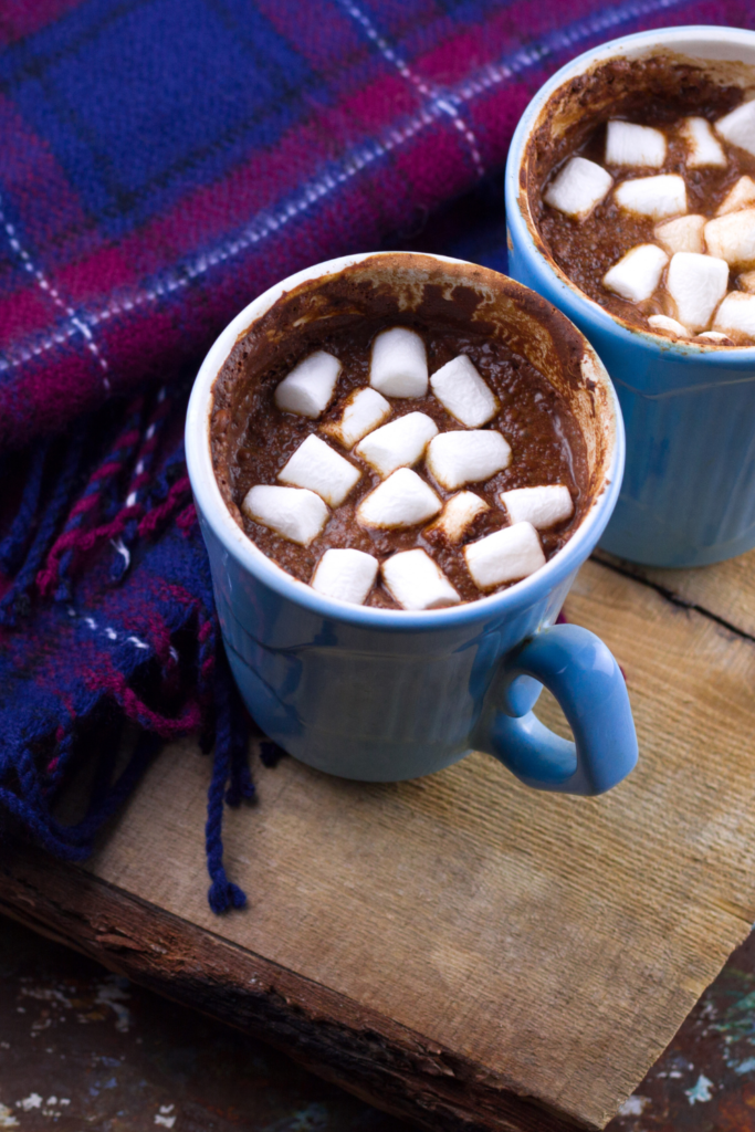 Hot chocolate in mugs and blanket for keeping guests warm at winter wedding